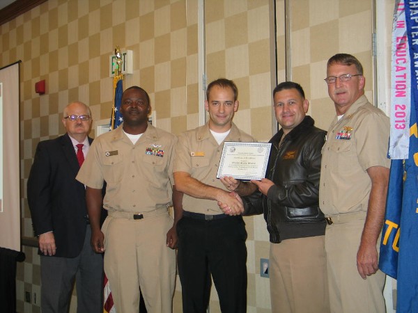 In October, Frazier (l), Lt. Cmdr. David Pereira, USN (2nd from r), chapter vice president, and Cmdr. Vanderlip (r) present the Military Cyber Professional of the Month Award to Information Systems Technician Wesley Miracle, USN (c).